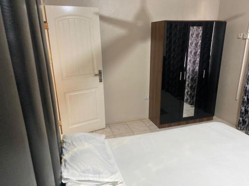 a room with a bed with a door and a mirror at Harmony house apartments in Ker Bakary