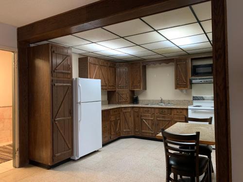 kuchnia z drewnianymi szafkami i białą lodówką w obiekcie Riverside Hotel w mieście Casper
