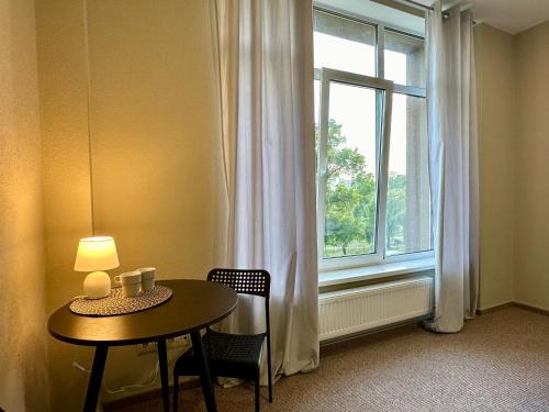 einen Tisch und Stühle in einem Zimmer mit Fenster in der Unterkunft 4Room Hostel in Kiew