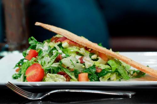 a salad on a white plate with a fork at Chicago Marriott Northwest in Hoffman Estates