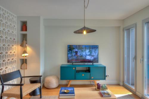 a living room with a blue cabinet and a tv at Blue Bay, charming home in Póvoa de Varzim