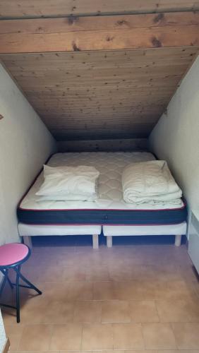 un lit dans une chambre avec un plafond en bois dans l'établissement Duplex au centre de la station, à Arâches-la-Frasse