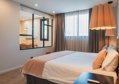 a bedroom with a large bed and a mirror at Gluck Patagonia Aparts in Villa La Angostura