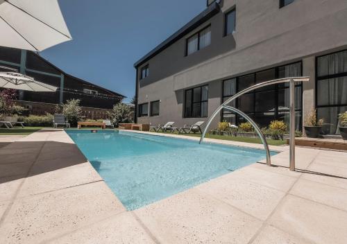 a swimming pool in front of a building at Gluck Patagonia Aparts in Villa La Angostura