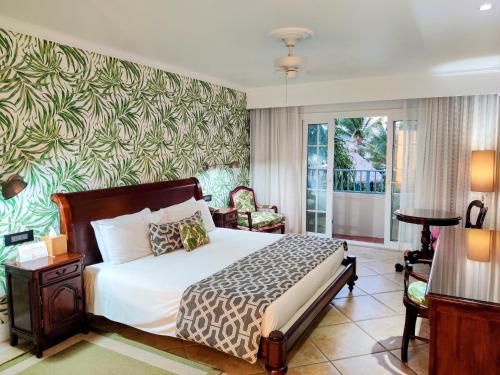 Coco Palm في جزيرة جورس: غرفة نوم بسرير وجدار أخضر