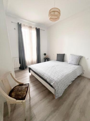 - une chambre blanche avec un lit et une chaise dans l'établissement Beau Duplex proche Paris, à Saint-Denis