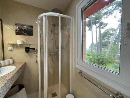 ein Badezimmer mit Dusche und Waschbecken und einem Fenster in der Unterkunft AfriKana in Arenas de San Pedro