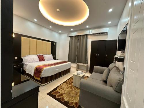 Habitación de hotel con cama y sofá en Zain Tabuk Apartment, en Tabuk