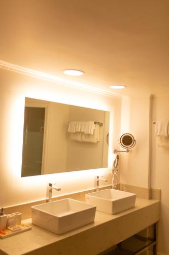 a bathroom with two sinks and a large mirror at Coco Palm in Gros Islet