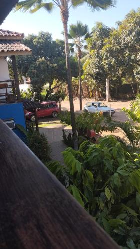 a view of a parking lot with palm trees and cars at Pousada Ponta da Baleia in Barra Grande