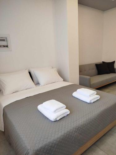a bedroom with a bed with three towels on it at Billy´s Seaside Apartment in Iraklitsa