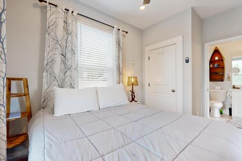 a bedroom with a large white bed and a window at In the Treetops in Dandridge
