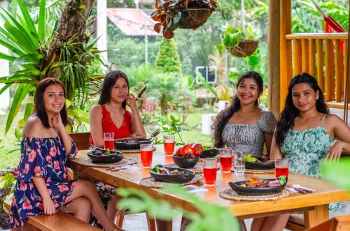 a group of women sitting around a wooden table at La Casa en el Aire Mindo, 4 Dormitorios in Mindo