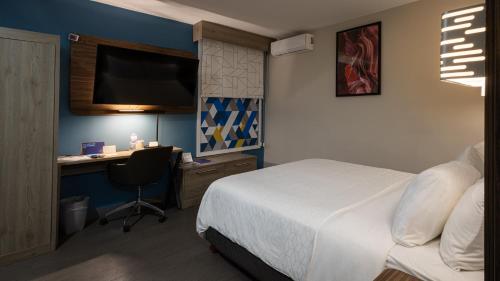 a bedroom with a bed and a desk with a computer at Holiday Inn Express Morelia Centro Historico in Morelia