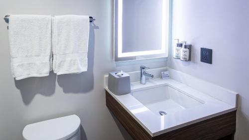 a bathroom with a sink and a toilet and towels at Holiday Inn Express Morelia Centro Historico in Morelia