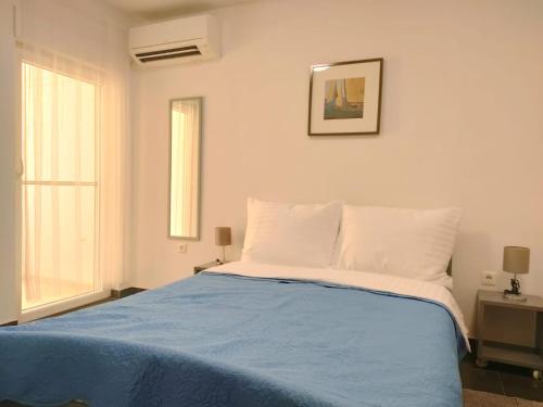 1 dormitorio con 1 cama con edredón azul en Rafael Apartments, en Medulin