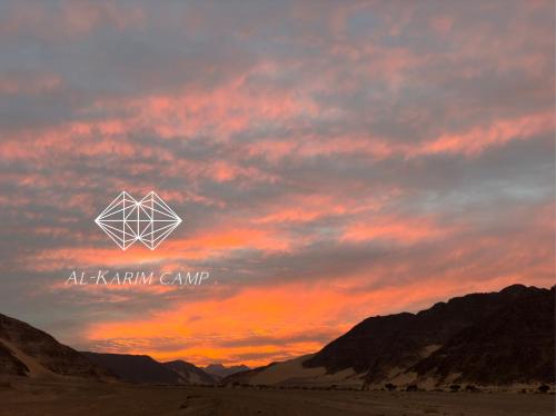 a sunset in the desert with a hexagon in the sky at aالكـريـم AL KARIM LUXURY CAMP in Wadi Rum