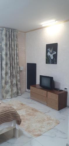 Три горішки في ياريمتشي: غرفة معيشة مع تلفزيون على دولاب خشبي