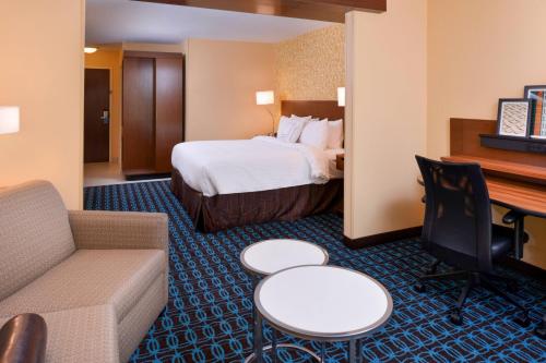 マーティンズバーグにあるFairfield Inn & Suites by Marriott Martinsburgのベッドとソファ付きのホテルルーム