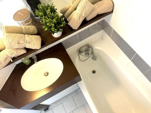 une salle de bain avec un lavabo et une baignoire dans l'établissement The Palm 100m de la plage Parking Clim Wifi, à La Grande Motte