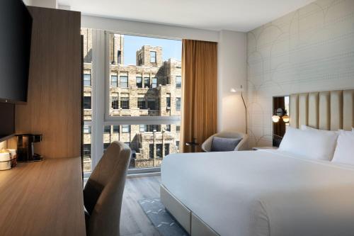 pokój hotelowy z łóżkiem i dużym oknem w obiekcie Courtyard by Marriott New York Manhattan / Soho w Nowym Jorku