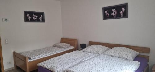 ゾーリンゲンにあるHome Sweet Homeの壁に2枚の写真が飾られたベッドルームのベッド2台