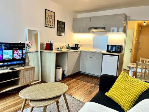 un salon avec un canapé et une cuisine dans l'établissement Le Pilori 2pers, chambre séparée, Tv et Wifi, à Nantes