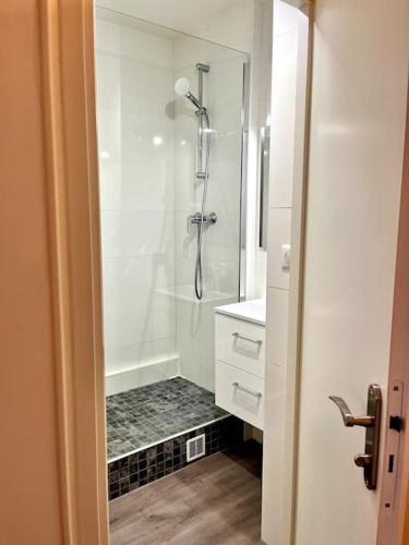 une salle de bain blanche avec une douche et un lavabo dans l'établissement Le Pilori 2pers, chambre séparée, Tv et Wifi, à Nantes