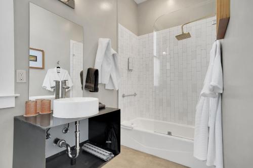 ein weißes Badezimmer mit einem Waschbecken und einer Badewanne in der Unterkunft Hanford House Inn in Sutter Creek