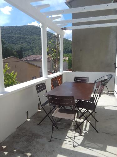 une table et des chaises sur un balcon avec vue dans l'établissement Gite les kiwis, à Bessèges