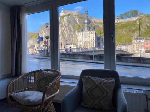 a room with two chairs and a window with a view at Vue Meuse, en face de la citadelle in Dinant