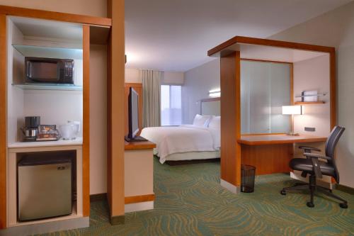 a hotel room with a bedroom with a bed and a desk at SpringHill Suites Coeur d'Alene in Coeur d'Alene