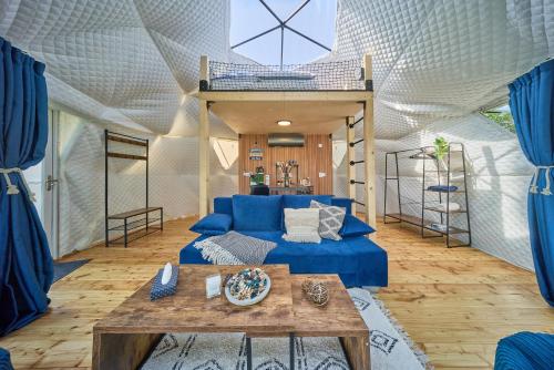 a living room with a blue couch in a tent at Glamping Slapy in Slapy