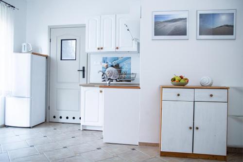 a kitchen with white cabinets and a refrigerator at Gwiazda Morska in Karwieńskie Błoto Pierwsze