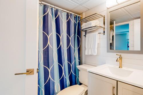 a bathroom with a blue shower curtain and a toilet at Sea Colony - 708 Brandywine House in Bethany Beach