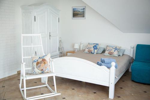sypialnia z białym łóżkiem i niebieską kanapą w obiekcie Gwiazda Morska w Karwieńskim Błocie