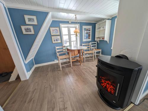 a living room with a fireplace and a table at Cabin magic on Senja, atmosphere like a fairytale in Botnhamn