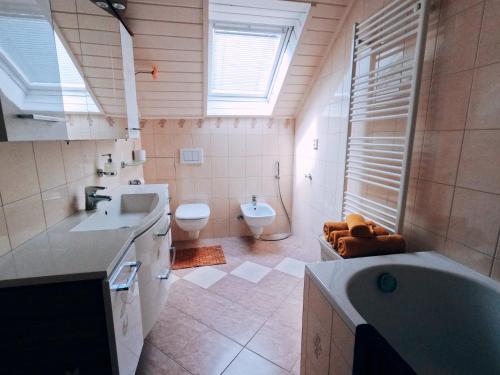 a bathroom with a sink and a toilet and a tub at Blumental apartment, garden, AC in Bratislava