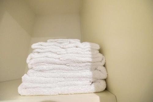 una pila di asciugamani bianchi appoggiata su un muro di Impeccable 2-Bed Apartment in Orpington a Orpington