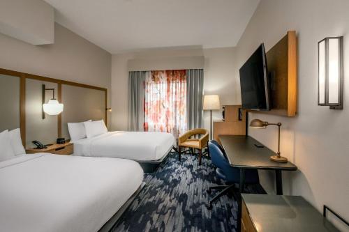 a hotel room with two beds and a desk at Fairfield Inn & Suites by Marriott Saratoga Malta in Malta