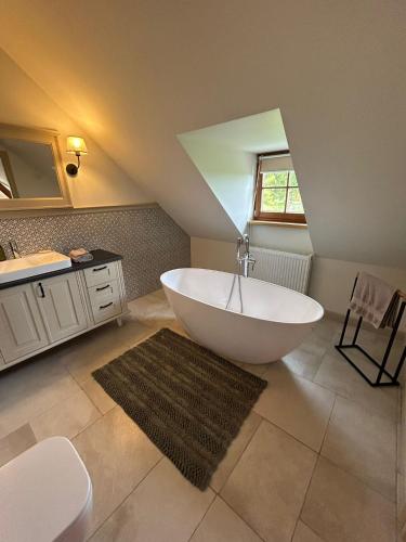 a bathroom with a large white tub and a sink at Nadbużański Świt Granne in Perlejewo