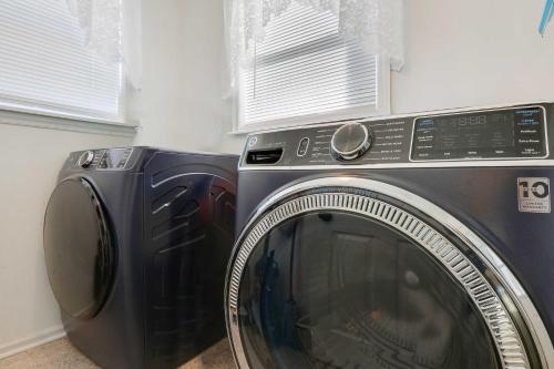 a washing machine in a room with two windows at Spacious Murphy Home with Game Room and Fire Pit! in Murphy