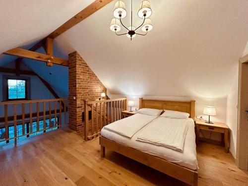 a bedroom with a bed and a chandelier at Nadbużański Świt Granne in Perlejewo