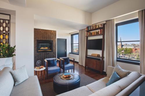 a living room with a couch and a fireplace at The Press Hotel, Autograph Collection in Portland