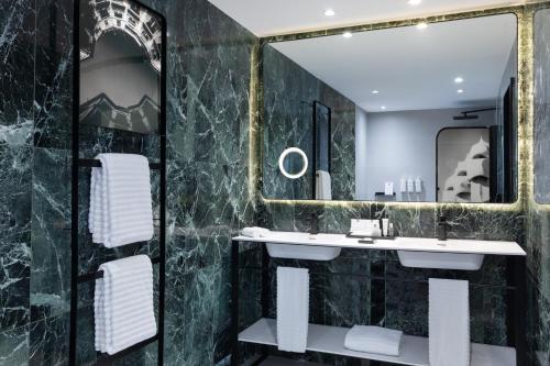 バルセロナにあるディプロマティック ホテル バルセロナのバスルーム(洗面台、鏡付)