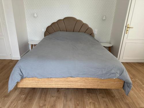 uma cama com uma cabeceira em madeira num quarto em Gîte de charme avec jolie vue em Saint-Lyphard