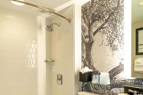 a bathroom with a shower with a tree mural on the wall at Williamsburg Lodge, Autograph Collection in Williamsburg