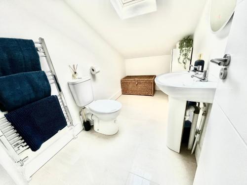 a white bathroom with a toilet and a sink at Maidstone City Centre Penthouse Apartment in Kent