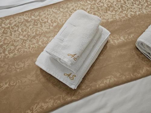 a pair of towels sitting on top of a bed at LUX Apartman AS - Montevia in Zlatibor