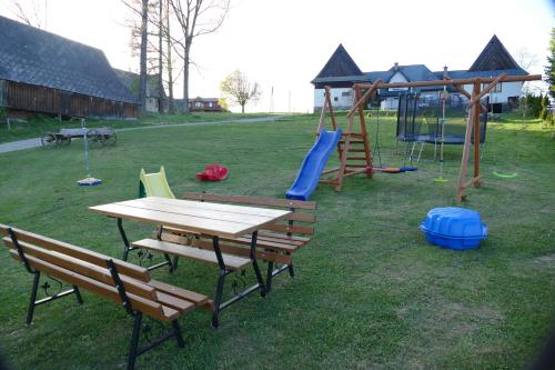 un parque infantil con mesa y columpio en Leszczyniański Domek en Biały Dunajec